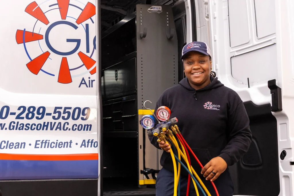 A Glasco technician smiling, and leaving a tech van.